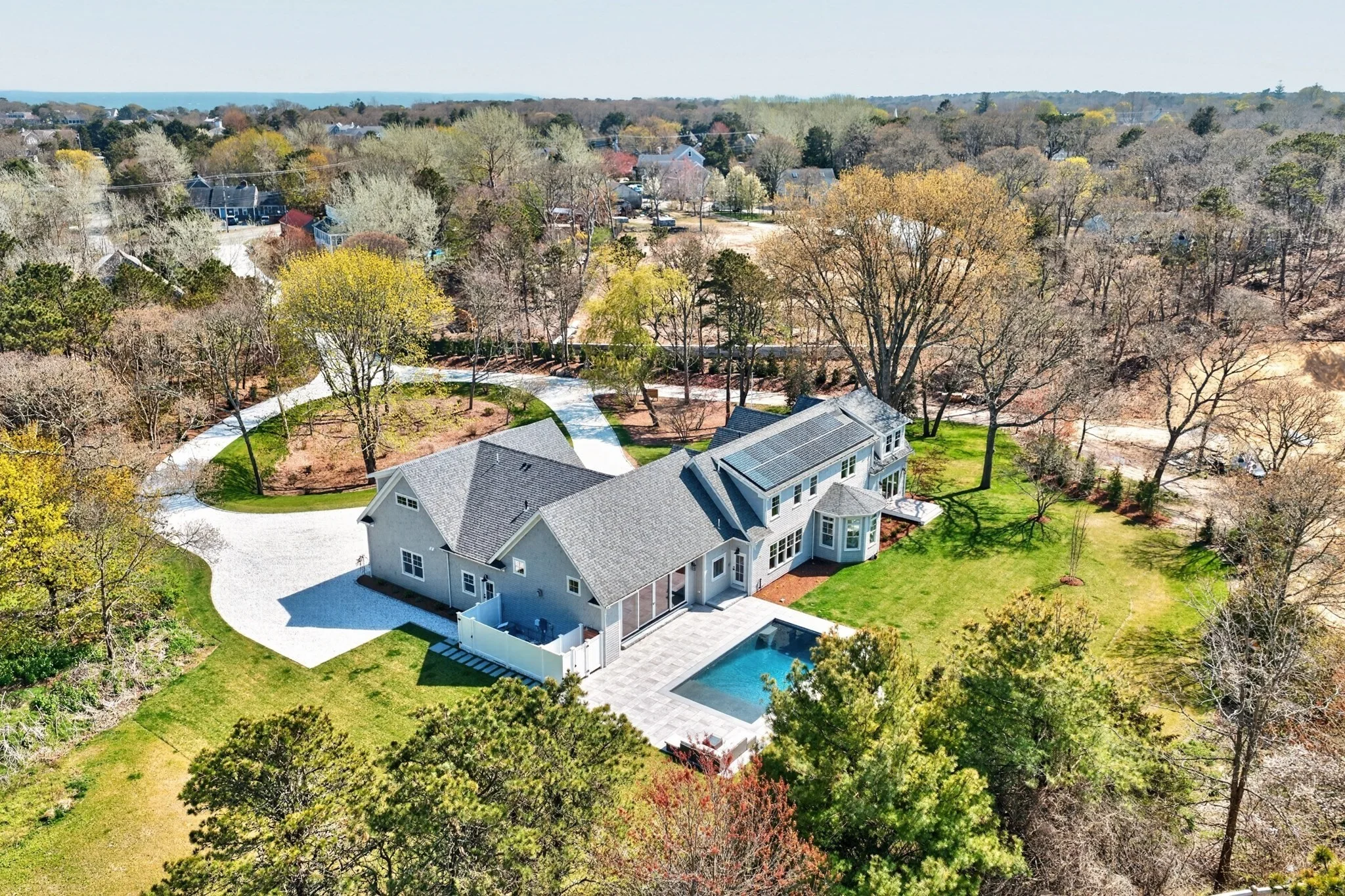 Aerial view of a home, lawn and backyard swimming pool