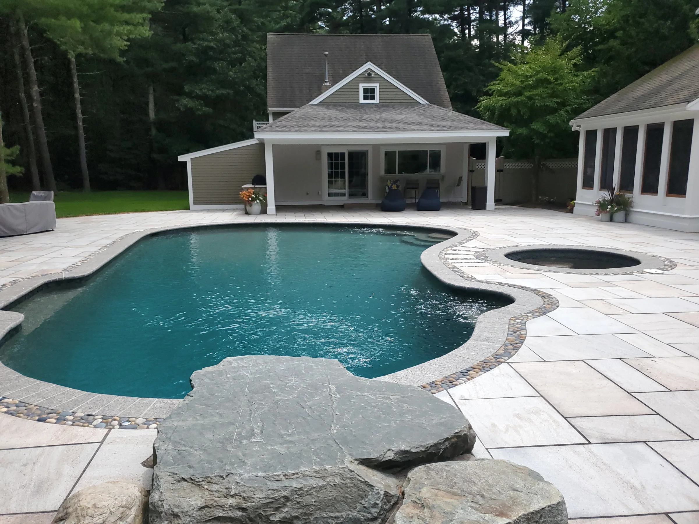Pool and spa terrace facing a compact pool house