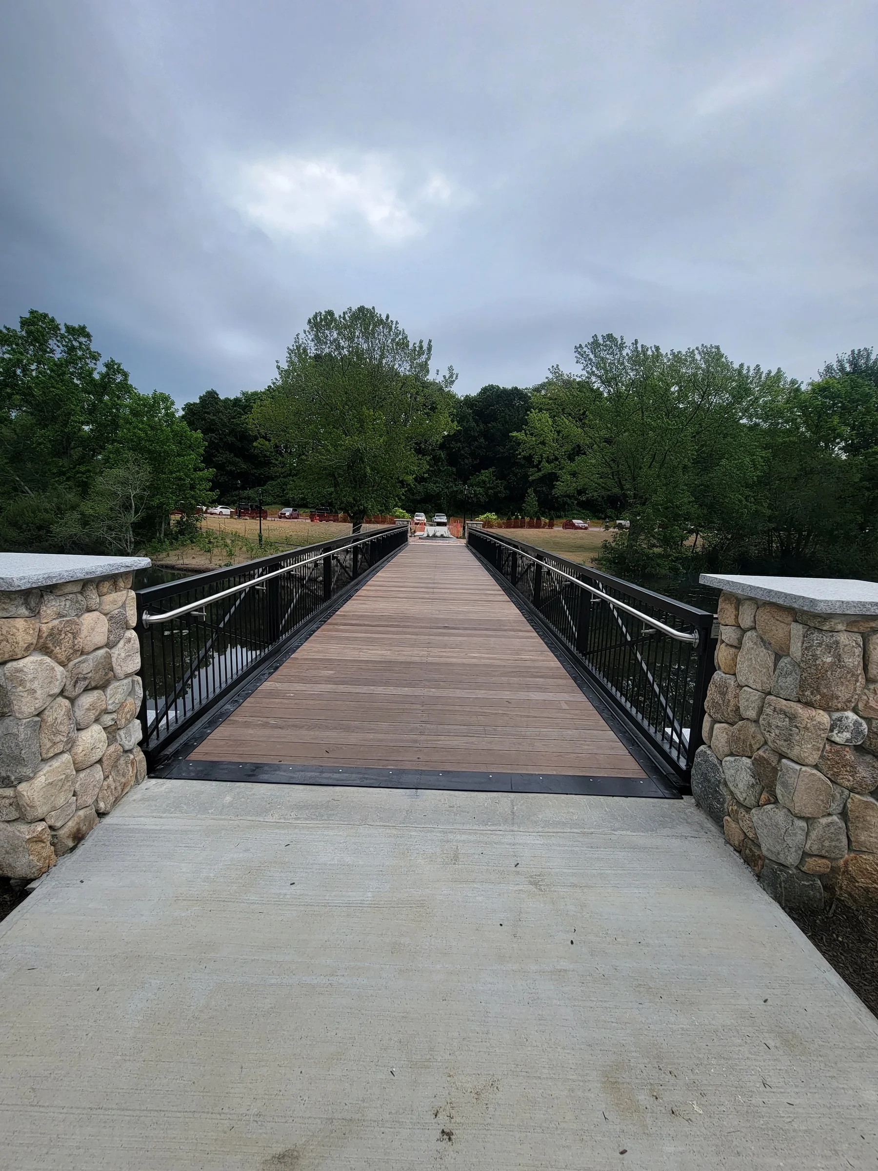 Bridge deck and stone piers beside a pond