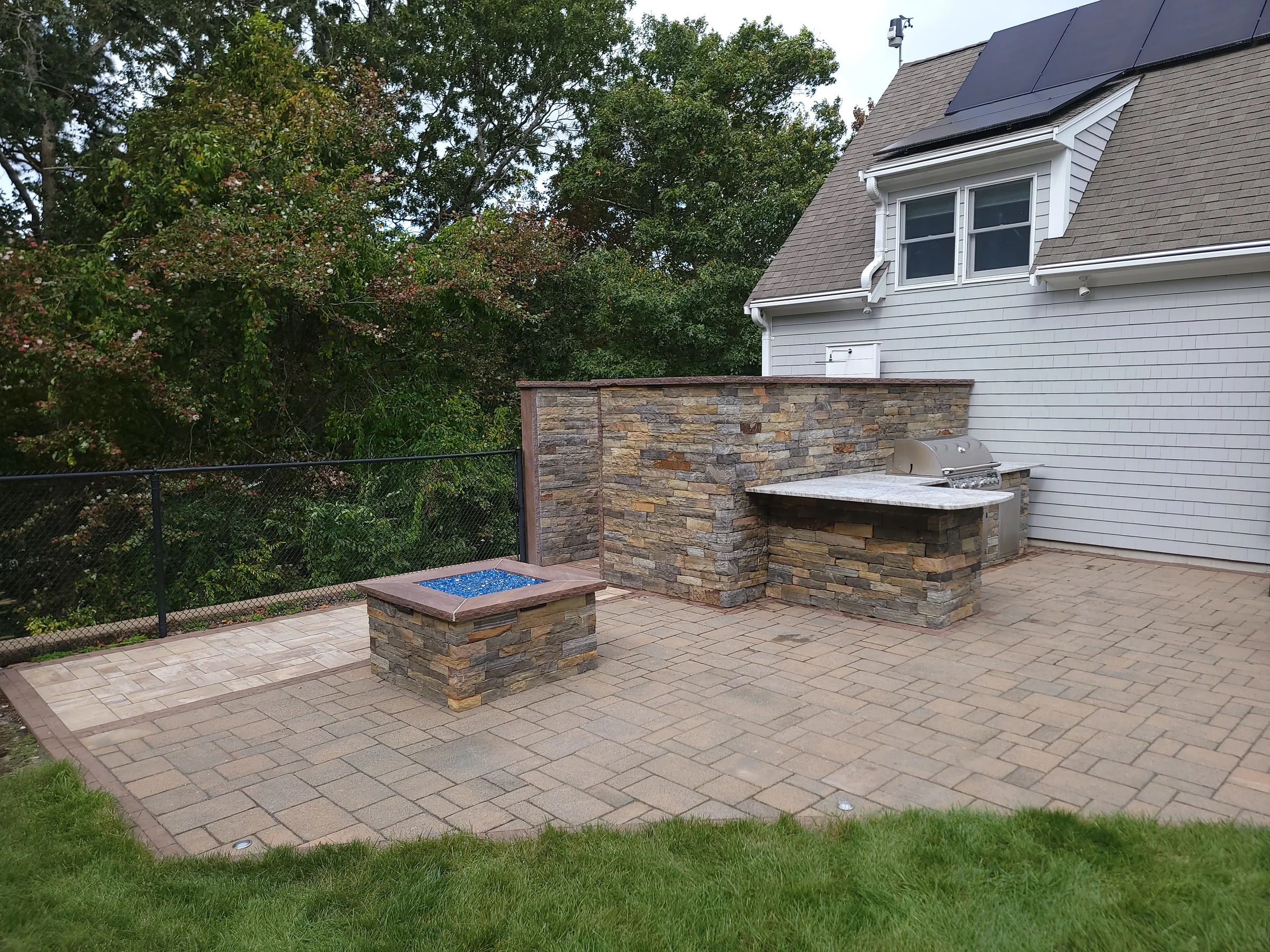 Backyard patio with built-in masonry features beside a home